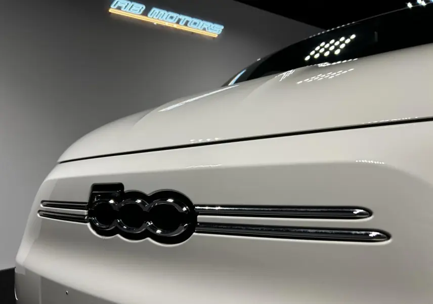 Gros plan sur la calandre avant blanche de la FIAT 500 électrique 2024 avec logo 500 noir brillant.