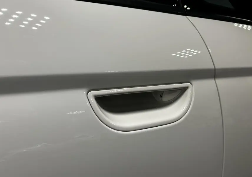 Poignée de porte blanche en gros plan sur le côté gauche d'une FIAT 500 électrique 2024.