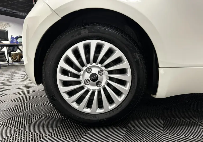 Gros plan sur la roue arrière droite blanche d'une FIAT 500 électrique 2024 avec jante acier 15 pouces.