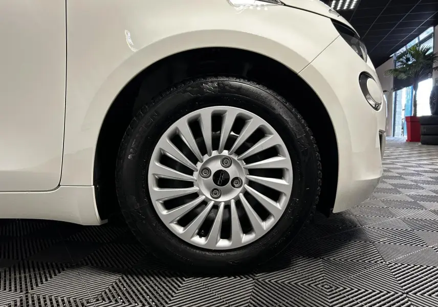 Gros plan sur la roue avant droite d'une FIAT 500 électrique blanche 2024 avec jante acier 15 pouces.