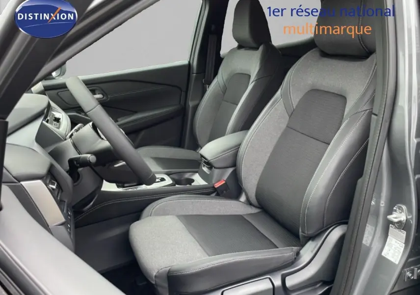 Vue intérieure côté conducteur du Nissan Qashqai 2025 gris squale métal, sièges tissu et cuir avec surpiqûres contrastées.