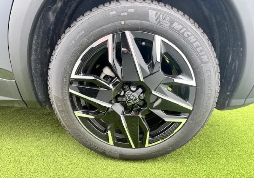 Gros plan sur la roue avant droite du Peugeot 3008 gris titane avec jante alliage noire et argentée diamantée.