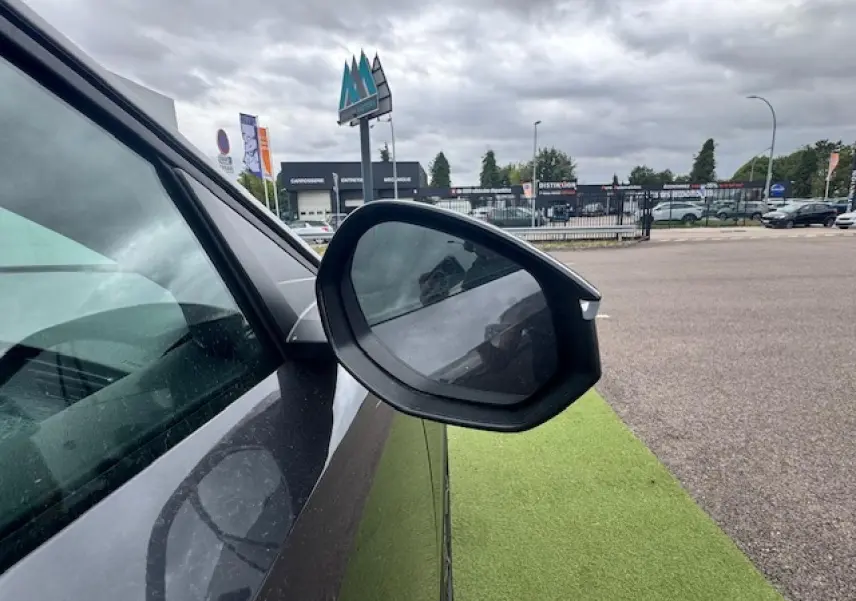 Rétroviseur côté gauche d’un Peugeot 3008 gris titane avec toit noir, vue rapprochée en extérieur.