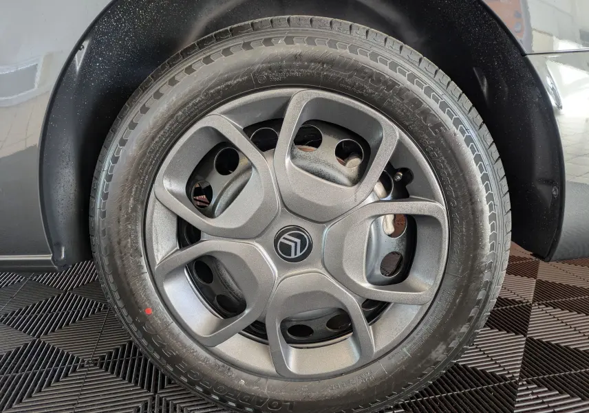 Gros plan sur la roue avant droite gris titane d'un Citroën Jumpy Cabine Approfondie avec jante tôle noire et enjoliveur gris.