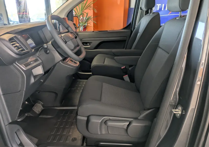 Vue intérieure côté conducteur du Citroën Jumpy Cabine Approfondie gris titane, sièges tissu noir avec accoudoir.