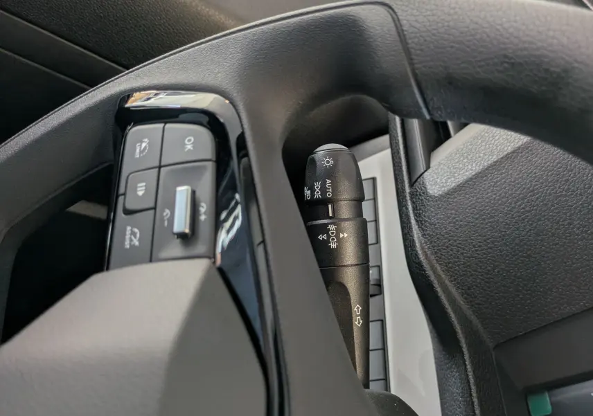 Détail intérieur côté conducteur du Citroën Jumpy gris, montrant commandes au volant et rétroviseur extérieur.