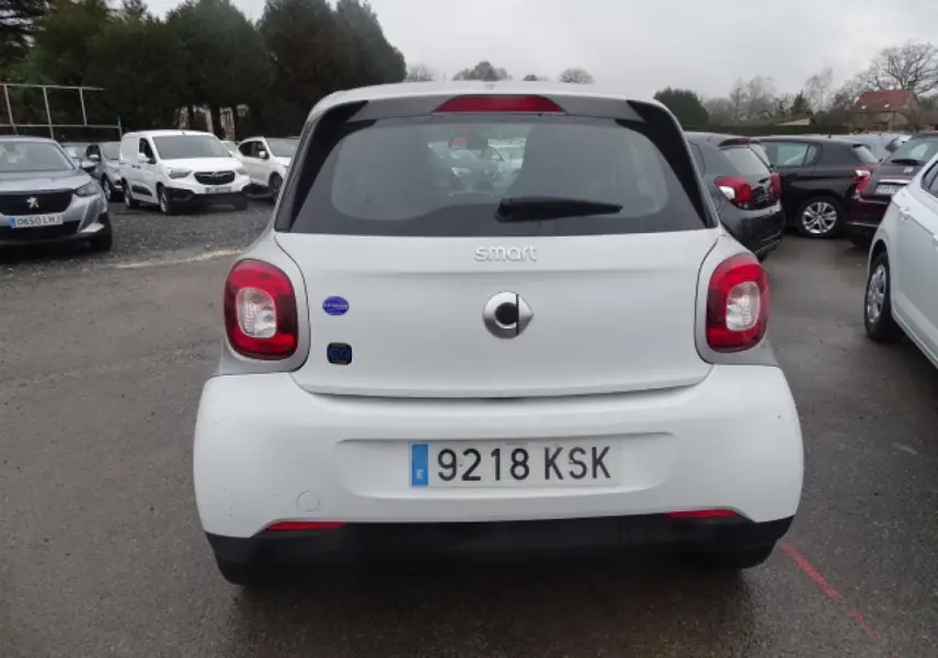 Vue arrière d'une Smart Forfour électrique blanche avec logo smart EQ et feux arrière rouges.