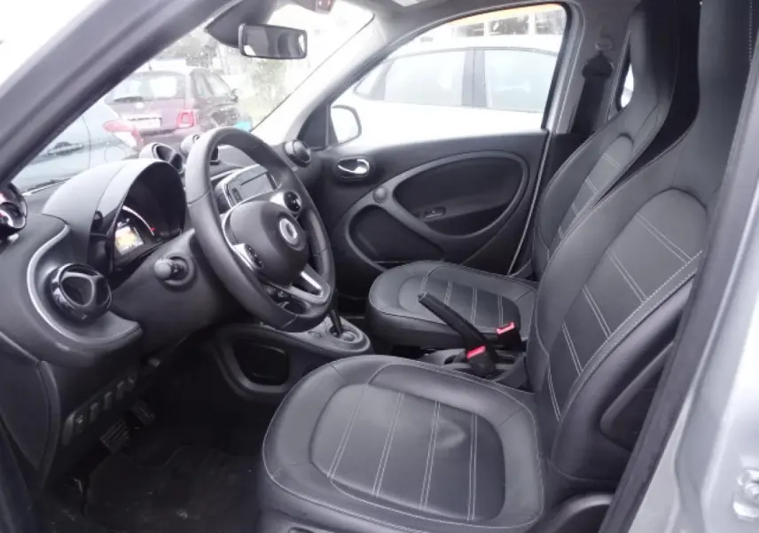 Vue intérieure côté conducteur de la Smart Forfour Electric Drive 2018, sellerie cuir noir et volant multifonctions.