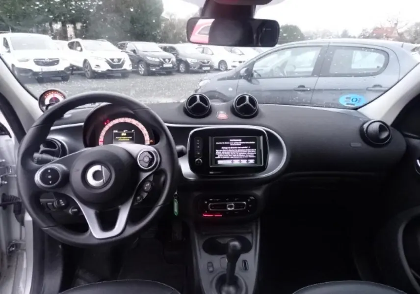 Vue intérieure avant du tableau de bord et volant cuir multifonctions de la Smart Forfour Electric Drive Prime blanche de 2018.