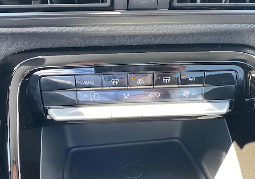 Gros plan sur la console centrale noire du Citroën C3 Aircross 2026, affichant les commandes de climatisation automatique.