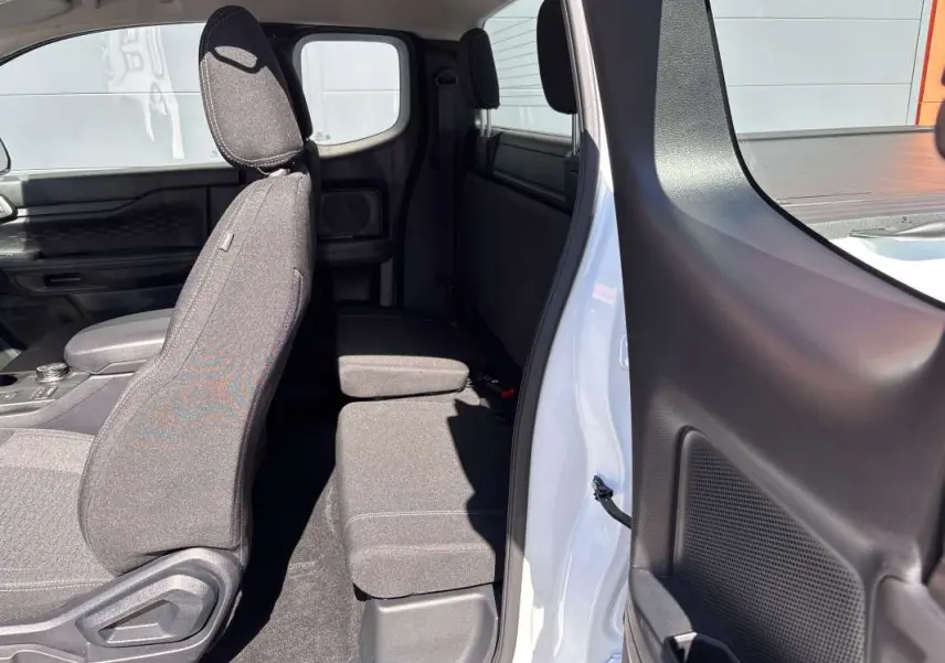Vue intérieure côté droit du Ford Ranger blanc glacier 2026, montrant les sièges avant et arrière en tissu gris.