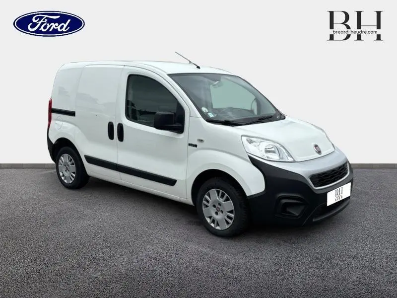 Fourgonnettte FIAT Fiorino blanc vue 3/4 avant droit avec portes latérales et pare-chocs noirs contrastants.
