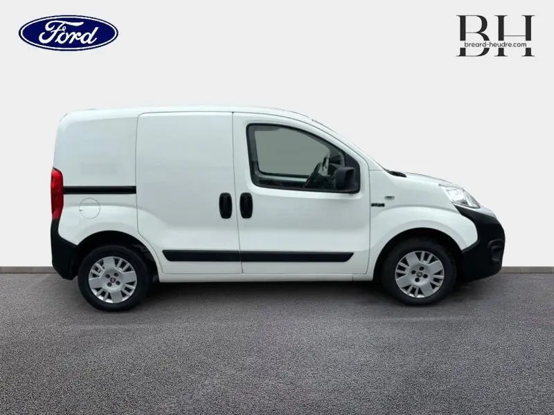 Profil droit d'un utilitaire blanc FIAT Fiorino 2018 avec portes latérales coulissantes et protections noires sur les bas de caisse.