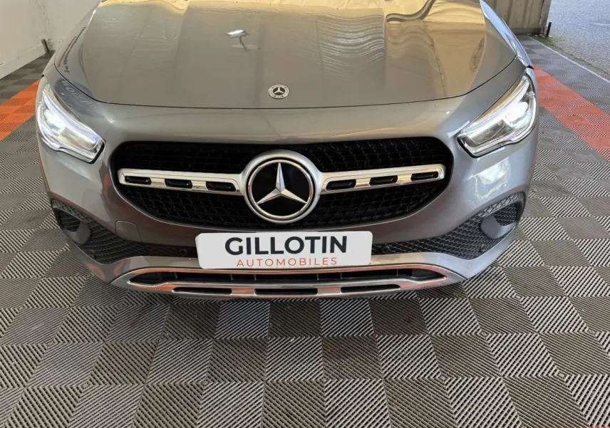 Vue avant rapprochée d’une Mercedes GLA 250 e Business Line gris foncé avec calandre étoile et plaque GILLOTIN.
