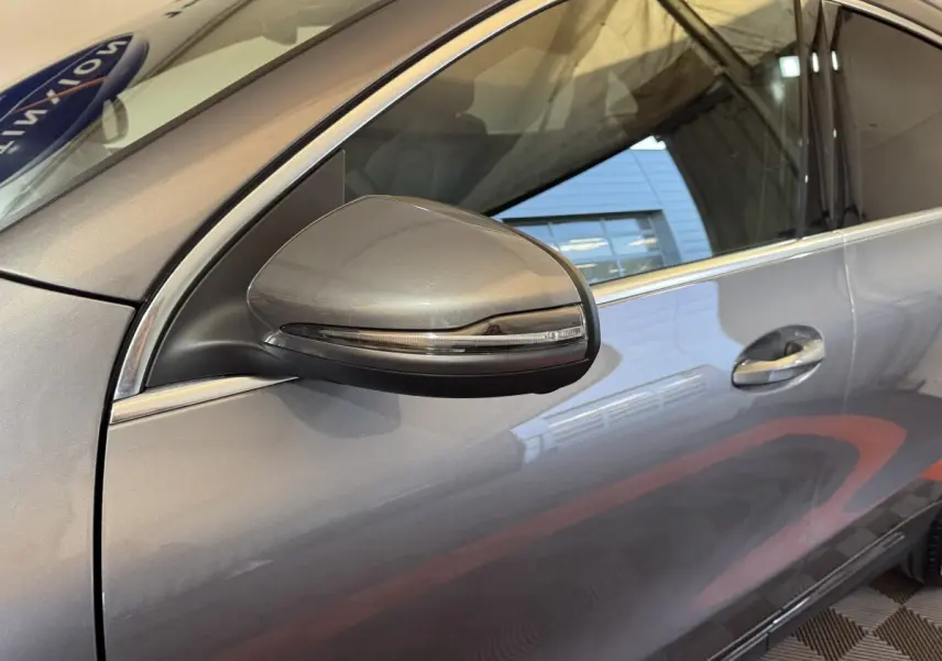 Gros plan sur le rétroviseur côté gauche gris foncé du Mercedes GLA 250 e Business Line 2023 avec porte et fenêtre visibles.