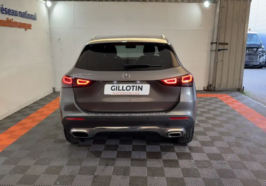Vue arrière d'une Mercedes GLA 250 e Business Line gris foncé avec feux LED allumés dans un garage.