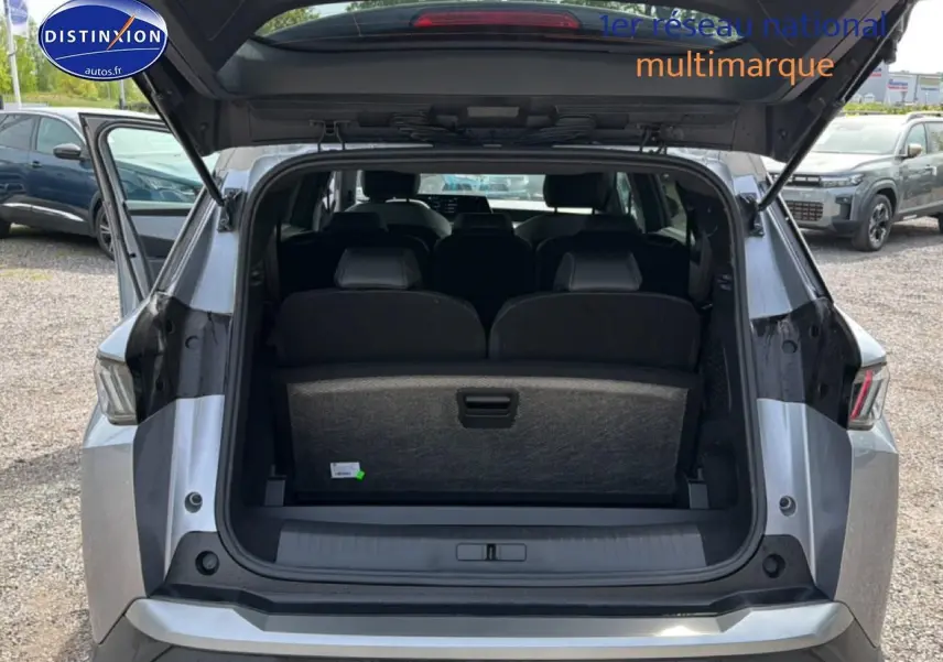 Vue arrière ouverte du Peugeot 5008 gris artense montrant les sièges rang 3 et le coffre spacieux.
