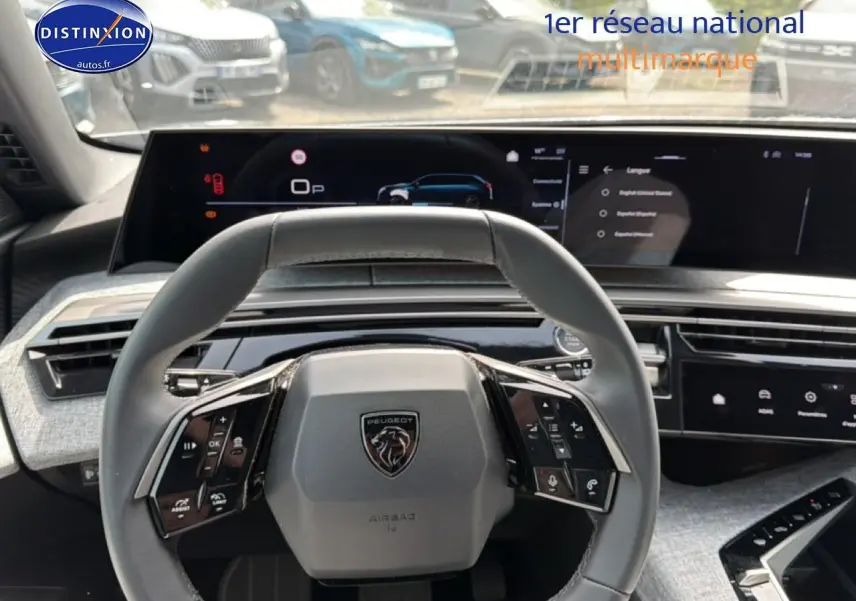 Vue intérieure centrée sur le volant cuir et le tableau de bord numérique du Peugeot 5008 gris Artense 2025.