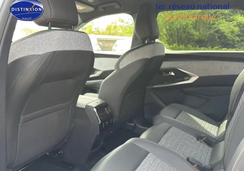 Vue intérieure arrière droite du Peugeot 5008 Hybrid 145 allure gris artense, sièges tissu et cuir bicolore.