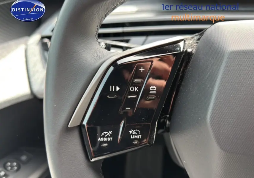 Gros plan sur les commandes multifonctions au volant cuir du Peugeot 5008 gris Artense, côté gauche.