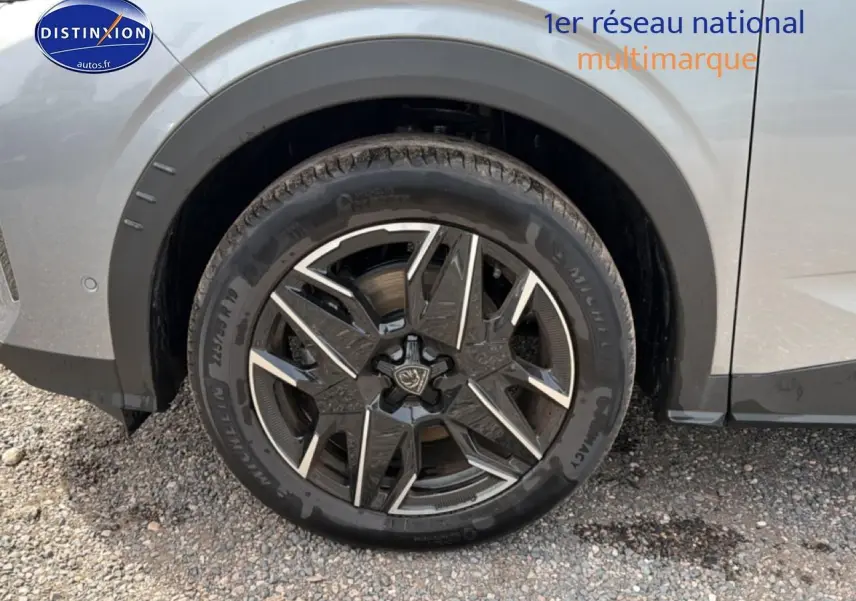 Gros plan sur la roue avant gauche du Peugeot 5008 gris Artense avec jante alu au design moderne.