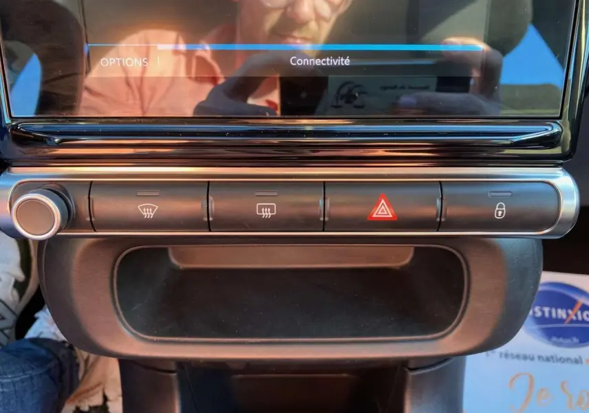 Gros plan sur la console centrale de la Citroën C3 2022 gris Artense, montrant les commandes de désembuage et d'alerte.