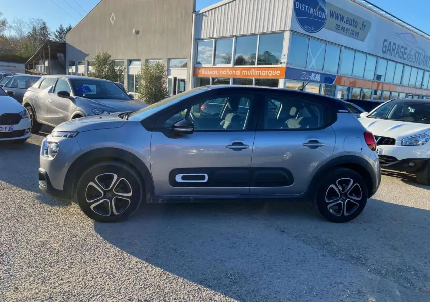 Profil latéral droit d'une Citroën C3 2022 gris Artense avec protections latérales noires et jantes alliage.