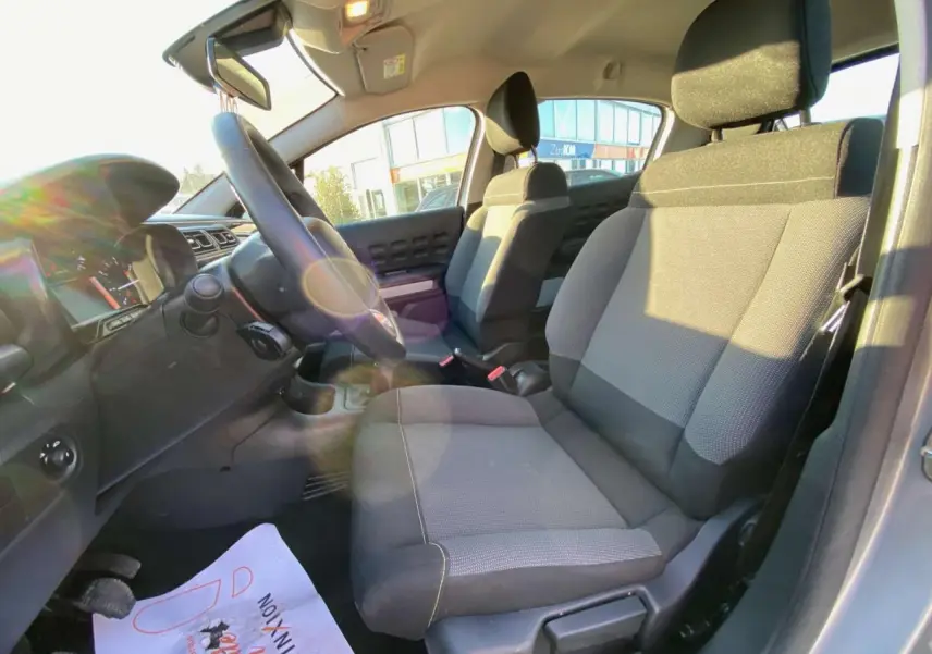 Vue intérieure côté conducteur de la Citroën C3 1.2L Feel Pack 2022 avec sièges gris et volant noir.