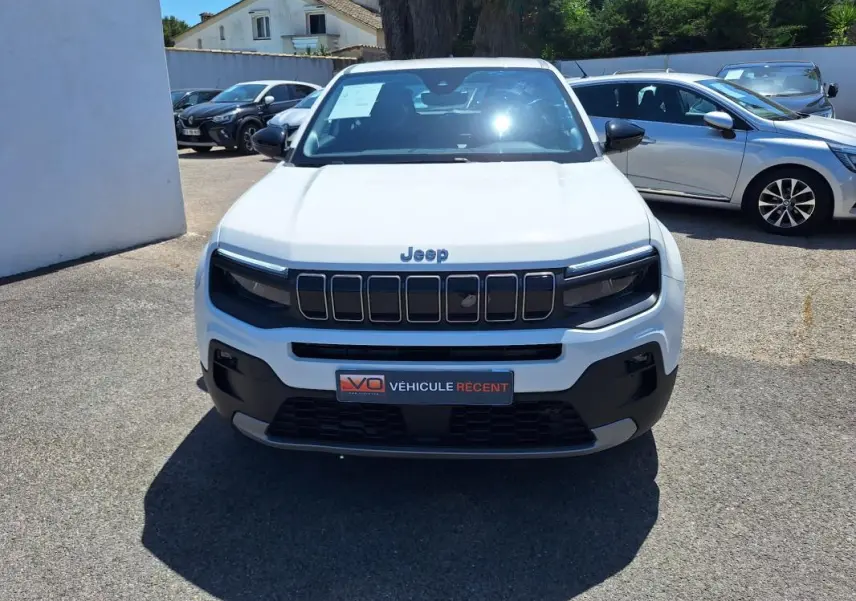 Vue de face d'un Jeep Avenger électrique blanc 2025 avec calandre noire et jantes alliage 17 pouces.