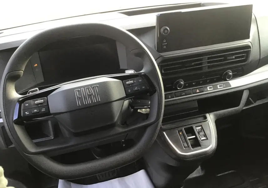 Vue intérieure du poste de conduite du Fiat Scudo Fourgon 2024, volant multifonction et écran tactile central noir.