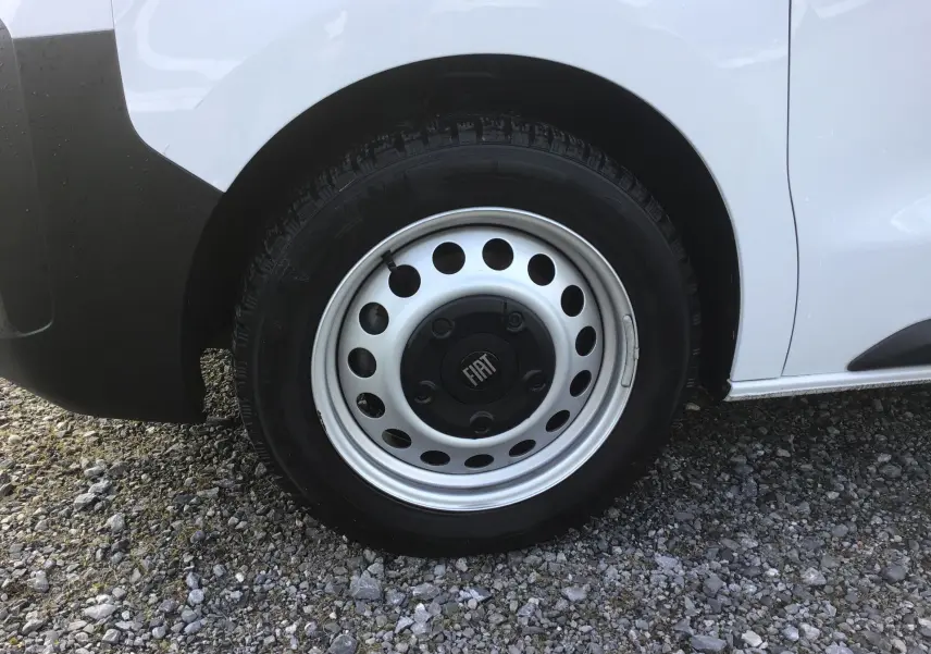 Gros plan sur la roue arrière droite blanche d’un FIAT Scudo Fourgon 2024 avec jante acier et logo central FIAT.