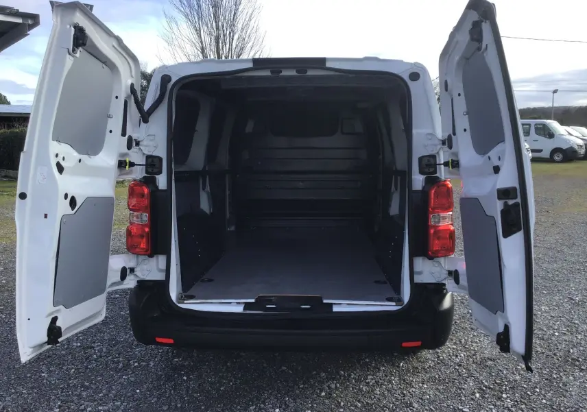 Vue arrière du FIAT Scudo Fourgon blanc 2024 avec portes battantes ouvertes montrant l’espace de chargement vide.