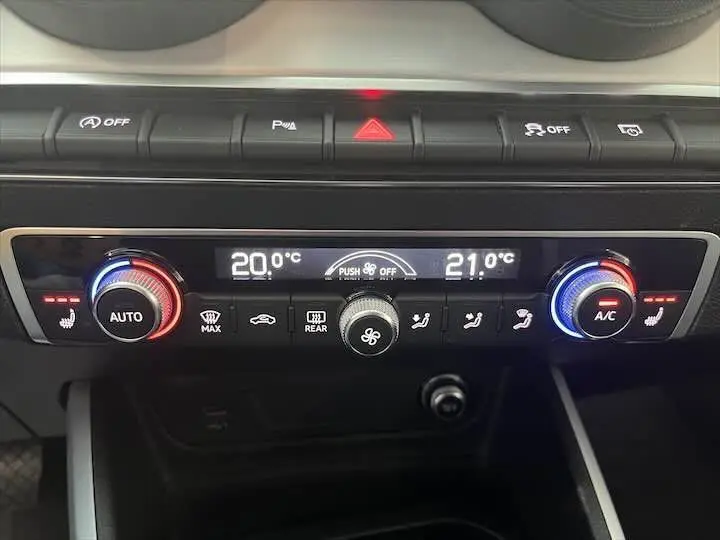 Panneau de climatisation digital de l'Audi Q2 35 TFSI 150 CH S-TRONIC 2020 avec réglages à 20 et 21°C et boutons chauffants.