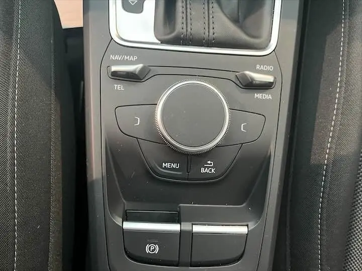 Gros plan sur la commande de régulateur de vitesse à gauche du volant dans l'habitacle gris d'un Audi Q2 2020.
