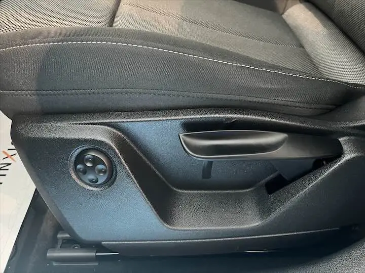 Gros plan sur la commande de réglage manuel du siège conducteur en tissu gris de l'Audi Q2 35 TFSI 2020.