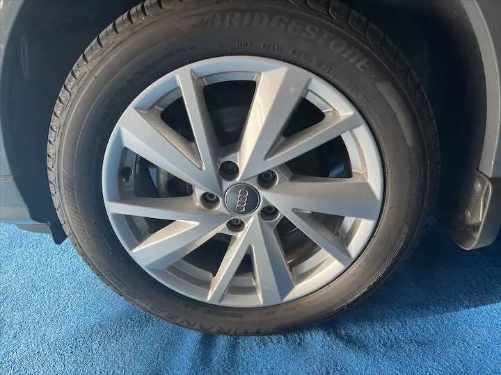 Gros plan sur la jante alliage argentée de l'Audi Q2 35 TFSI gris Daytona, avec pneu Bridgestone visible.