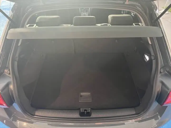 Coffre ouvert vu de l'arrière d'un Audi Q2 gris Daytona, montrant un espace de chargement propre et spacieux.