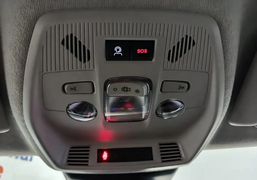 Vue en gros plan du plafonnier gris avec bouton SOS et commandes d'éclairage dans une Citroën C3 noire hybride 2025.