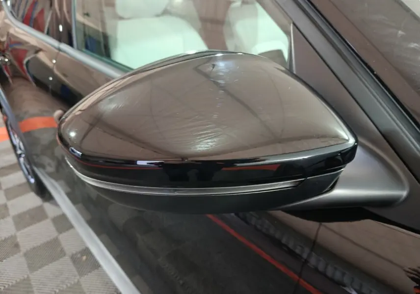 Gros plan sur le rétroviseur côté gauche noir brillant de la Citroën C3 hybride 2025 avec clignotant intégré.