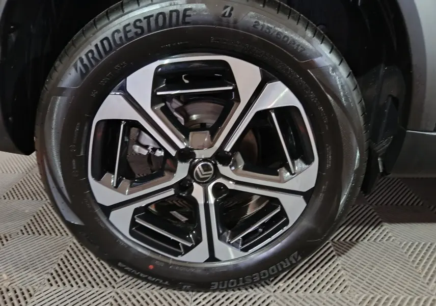 Gros plan sur la jante alliage noire et argentée de la Citroën C3 Hybride 136 e-DSC6 MAX, pneu Bridgestone visible.