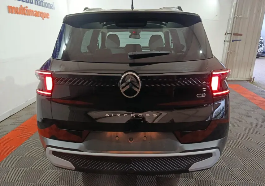 Vue arrière d'un Citroën C3 Aircross noir avec feux arrière allumés dans un garage intérieur.