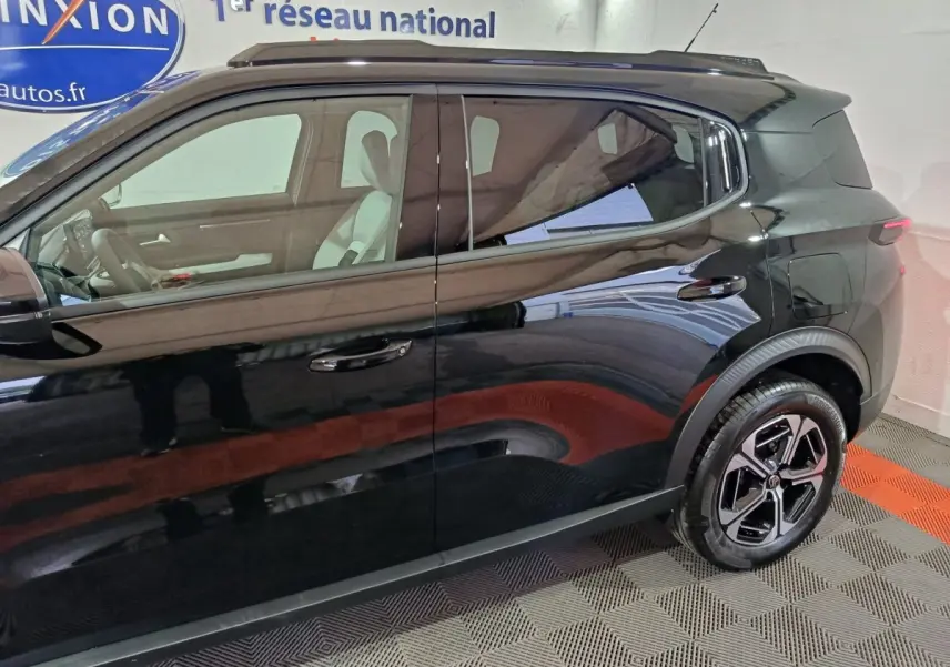 Vue latérale gauche d'une Citroën C3 hybride noire 2025, mettant en valeur ses jantes et la ligne de toit compacte.