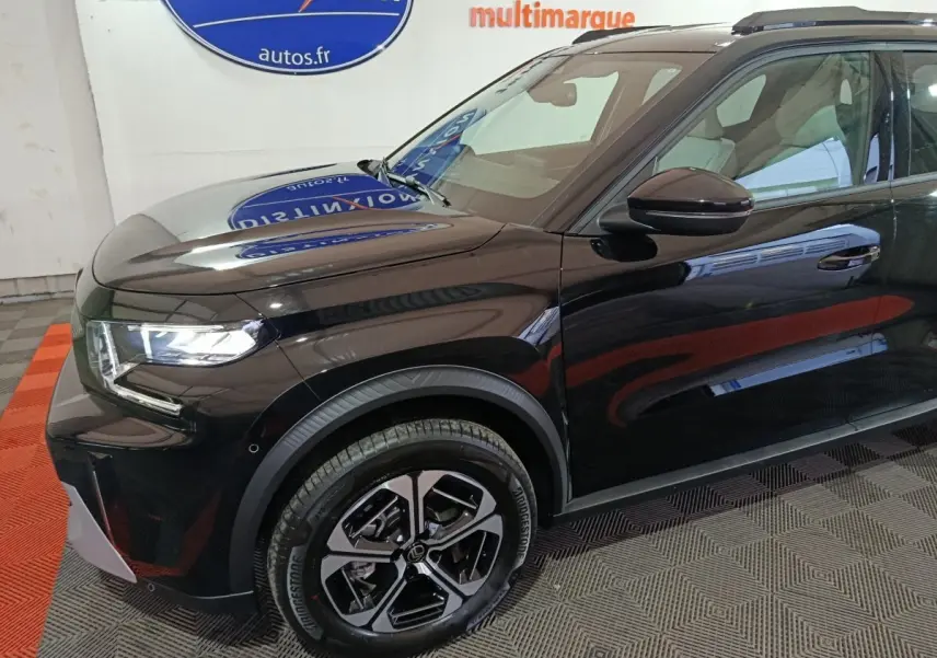 Vue 3/4 avant gauche d'une Citroën C3 hybride noire, avec jantes modernes et phares LED allumés.