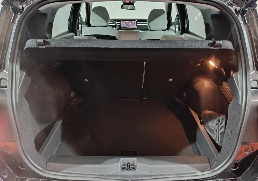 Coffre ouvert vu de l'arrière d'une Citroën C3 noire hybride 2025, intérieur spacieux et banquette arrière visible.