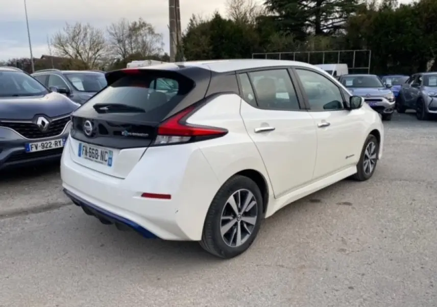 Vue 3/4 arrière droite d'une Nissan Leaf 40 kWh blanche avec toit noir et feux arrière LED distinctifs.