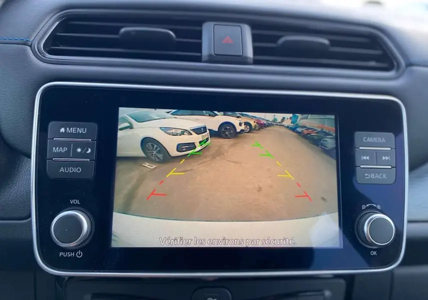 Écran tactile central montrant la caméra de recul avec guidage coloré, intérieur noir du Nissan Leaf blanc 2020.