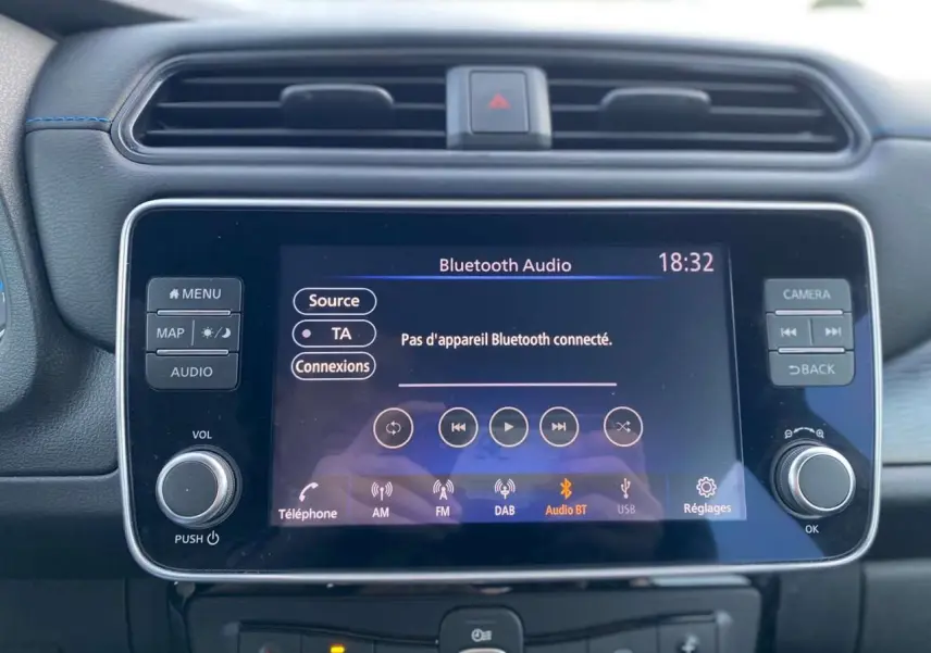 Vue rapprochée de l’écran tactile central du tableau de bord du Nissan Leaf blanc 2020, affichant la connexion Bluetooth audio.
