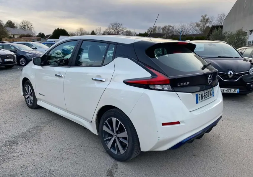 Vue 3/4 arrière droite d'une Nissan Leaf blanche 2020 avec toit noir et feux arrière LED distinctifs.