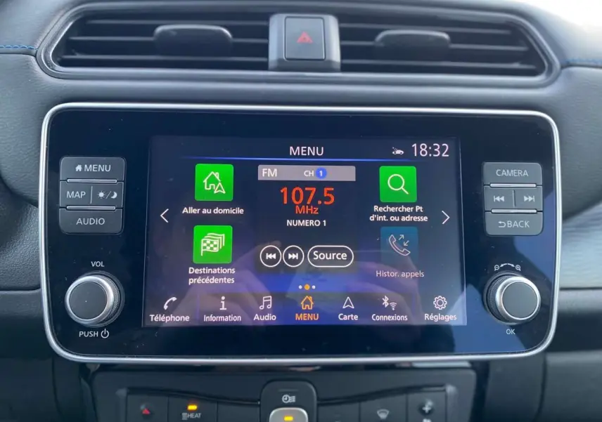 Écran tactile central du tableau de bord de la Nissan Leaf 40 kWh blanc, affichant le menu radio FM à 18h32.
