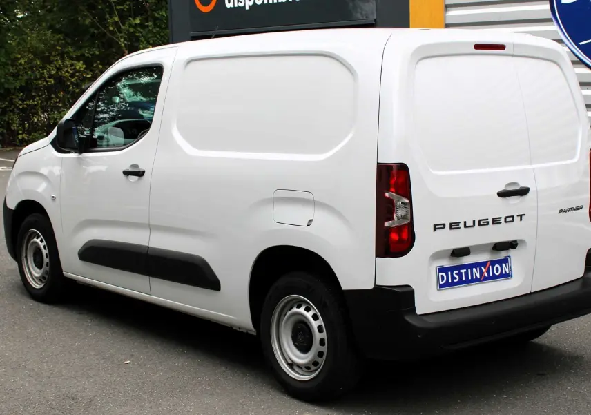 Vue 3/4 arrière droite du Peugeot Partner Fourgon blanc 2025 avec logo distinctif et porte latérale pleine.